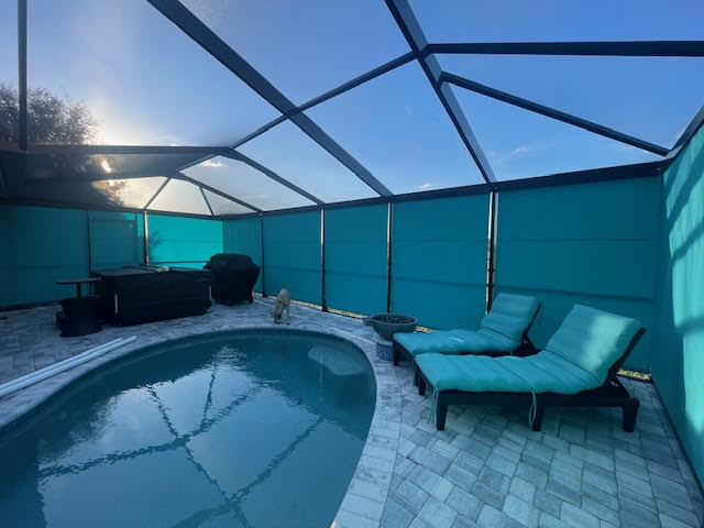 Teal roller shades on pool lanai with lounge chairs